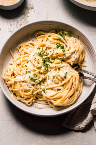 Serving bowl of pasta with parmesan cream sauce.