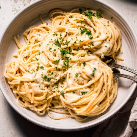Serving bowl of pasta with parmesan cream sauce.