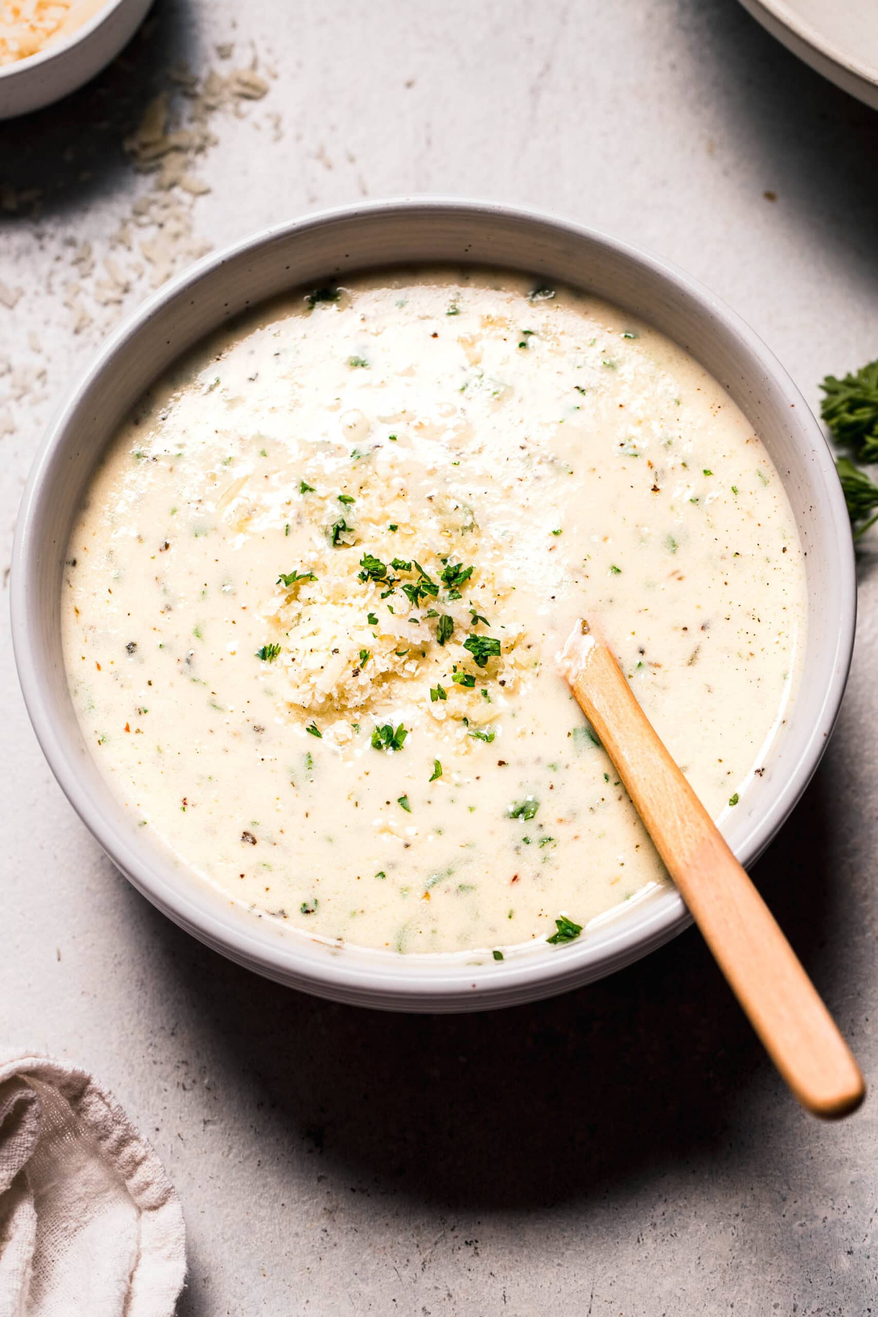 Side view of parmesan cream sauce in serving bowl.