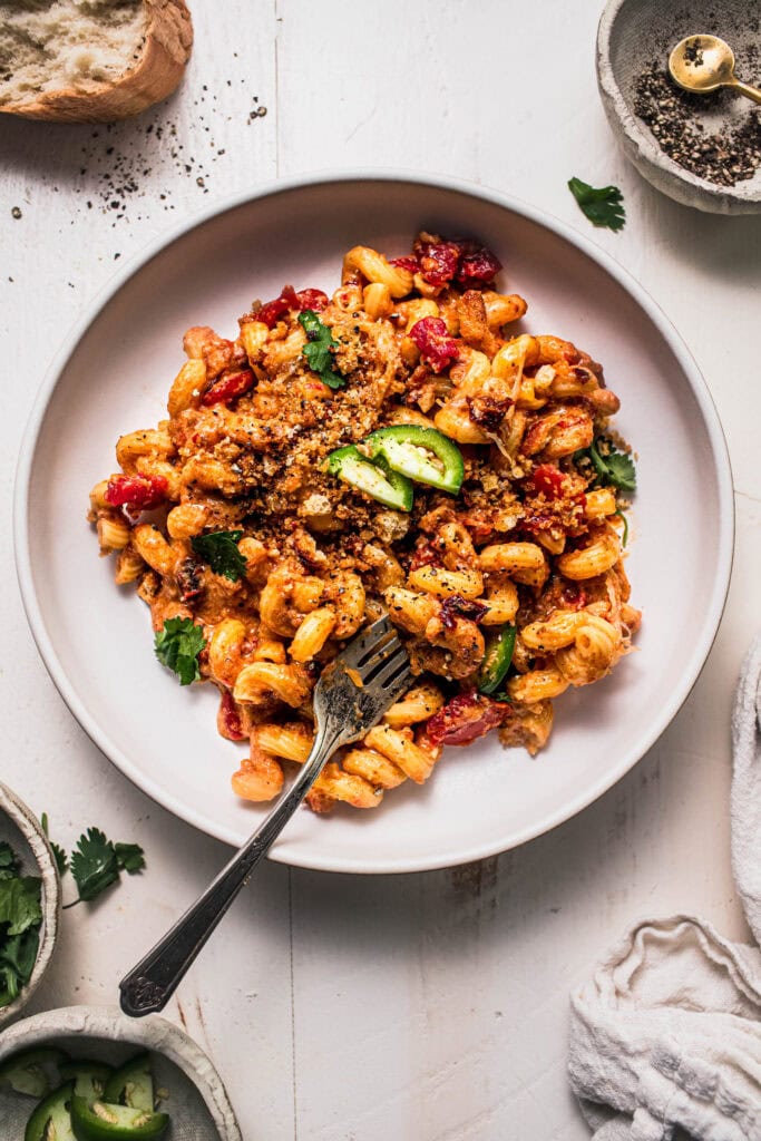 Chorizo mac and cheese in bowl with serving bowl.