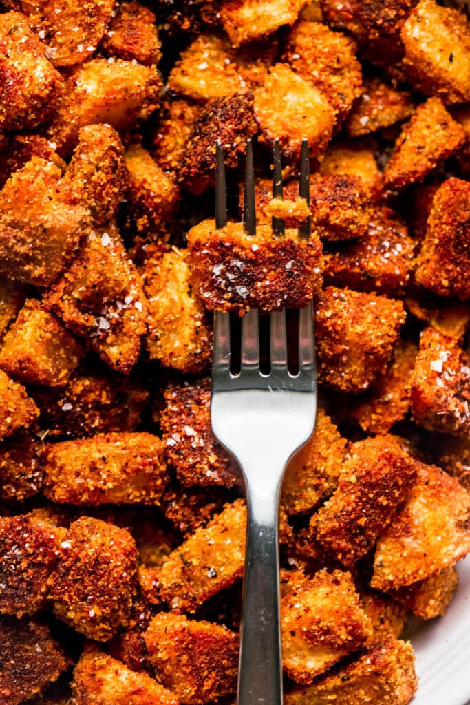 Crispy shake and bake potato stabbed on fork.