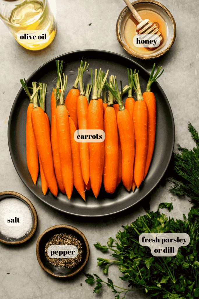 Ingredients for honey roasted carrots labeled on counter.