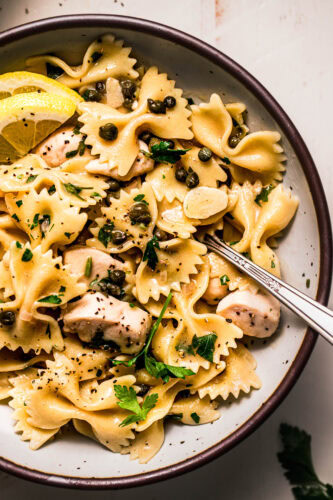 Close up of chicken piccata pasta in serving bowl.
