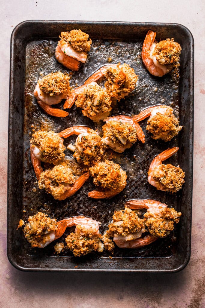 Baked crab stuffed shrimp on baking sheet.