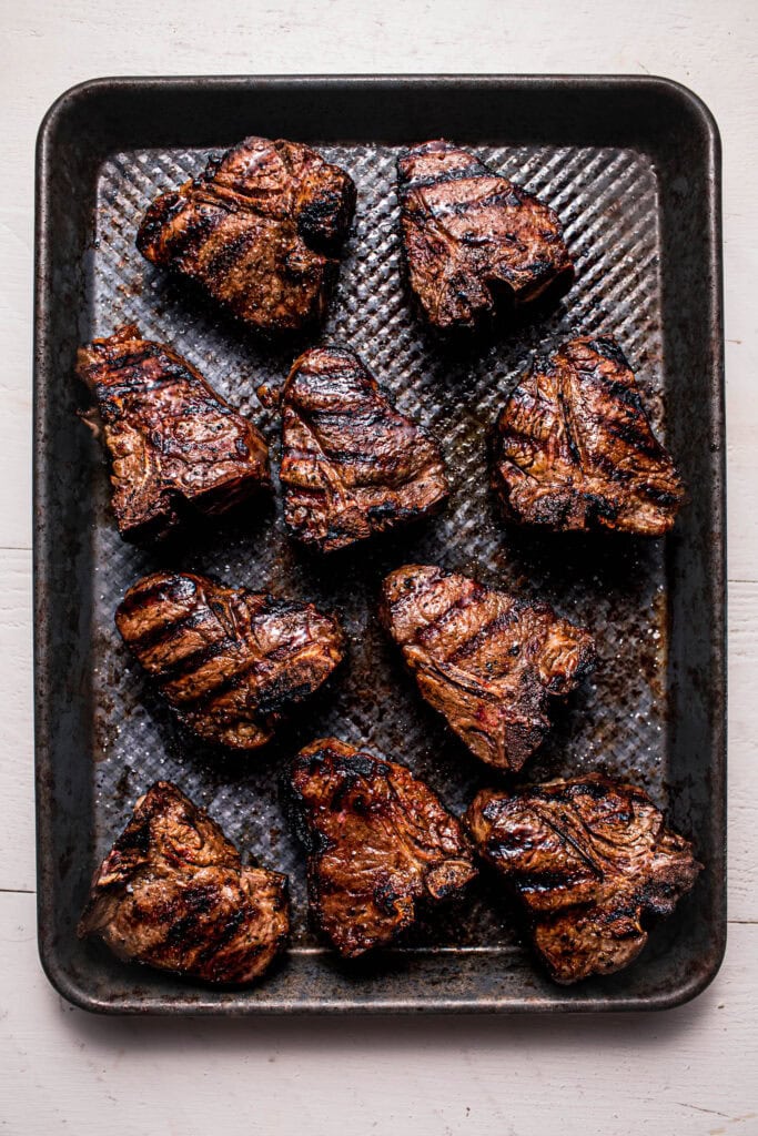 Grilled lamb chops resting on pan.