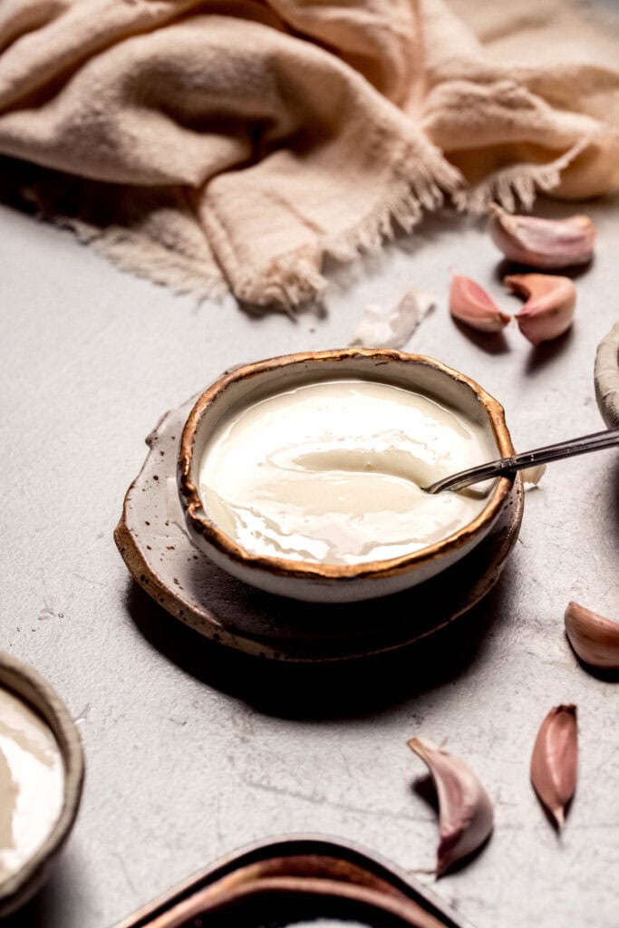 Spoon in bowl of homemade garlic aioli.