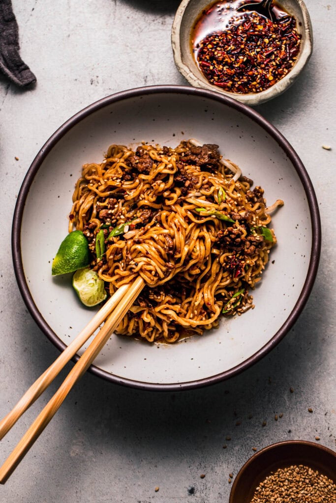 Finished ground beef ramen in bowl with chopsticks.