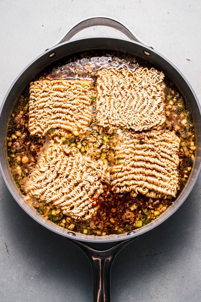 Ramen noodles added into skillet.