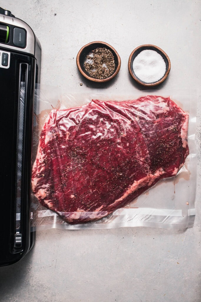 Flank steak being sealed in bag.