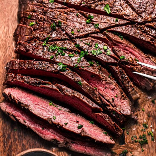 Close up of sliced flank steak on cutting board.