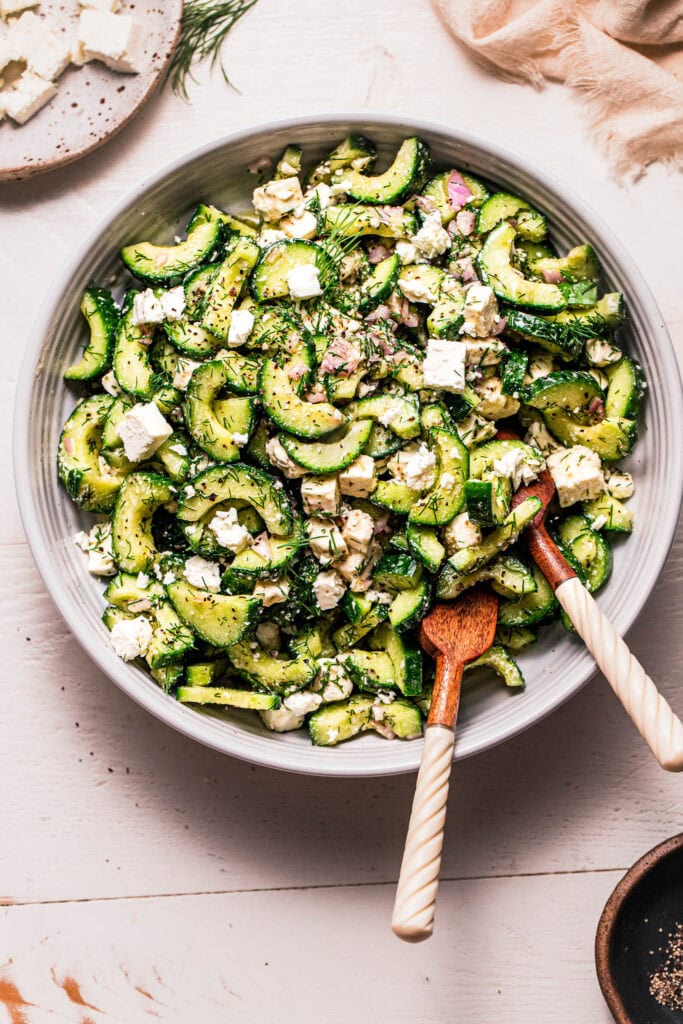 Cucumber salad with feta in serving bowl.