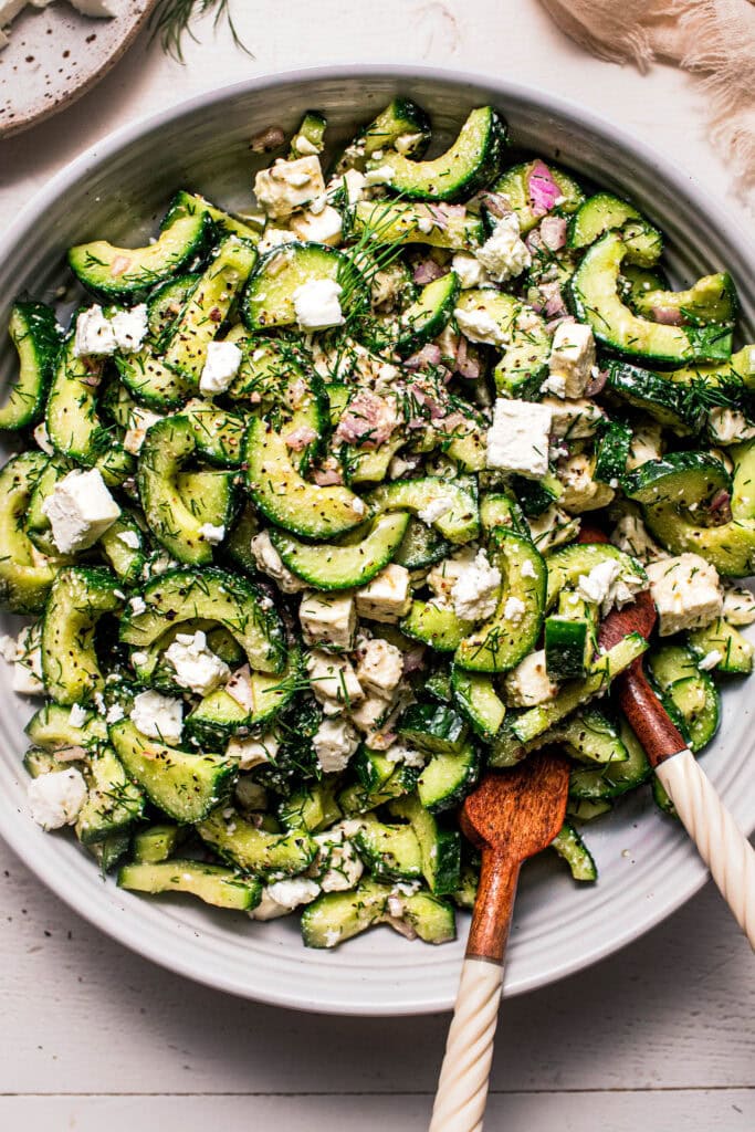 Overhead close up of feta cucumber salad in serving bowl.