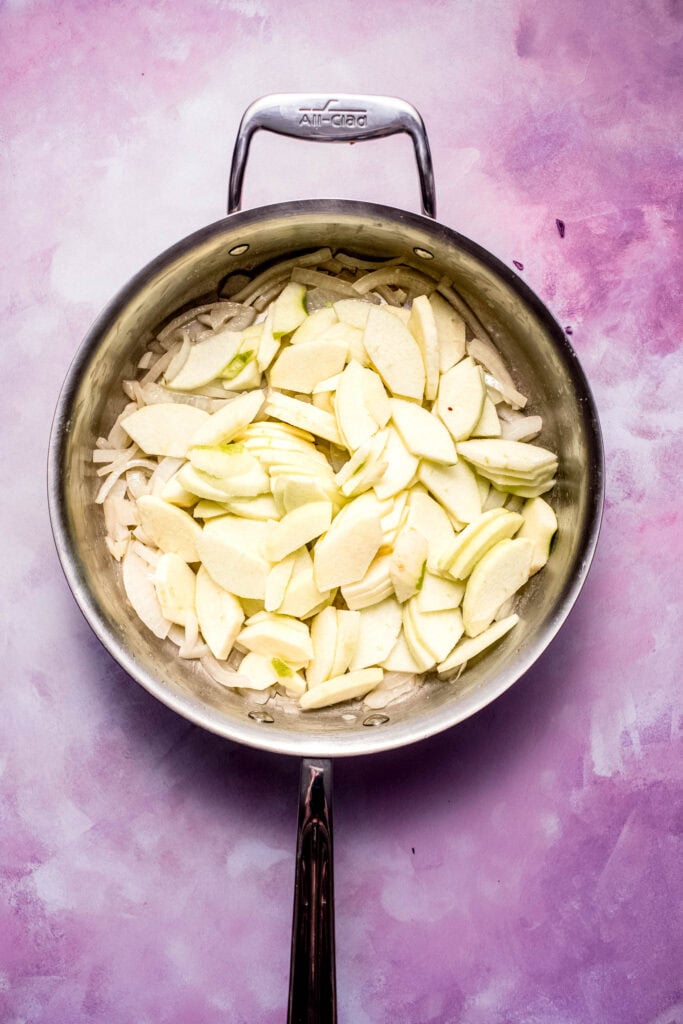 Sliced apples added to skillet.