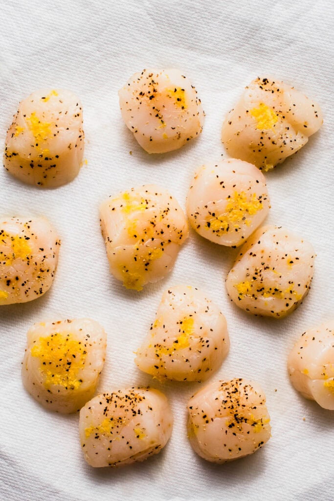 Scallops sprinkled with pepper and lemon zest.