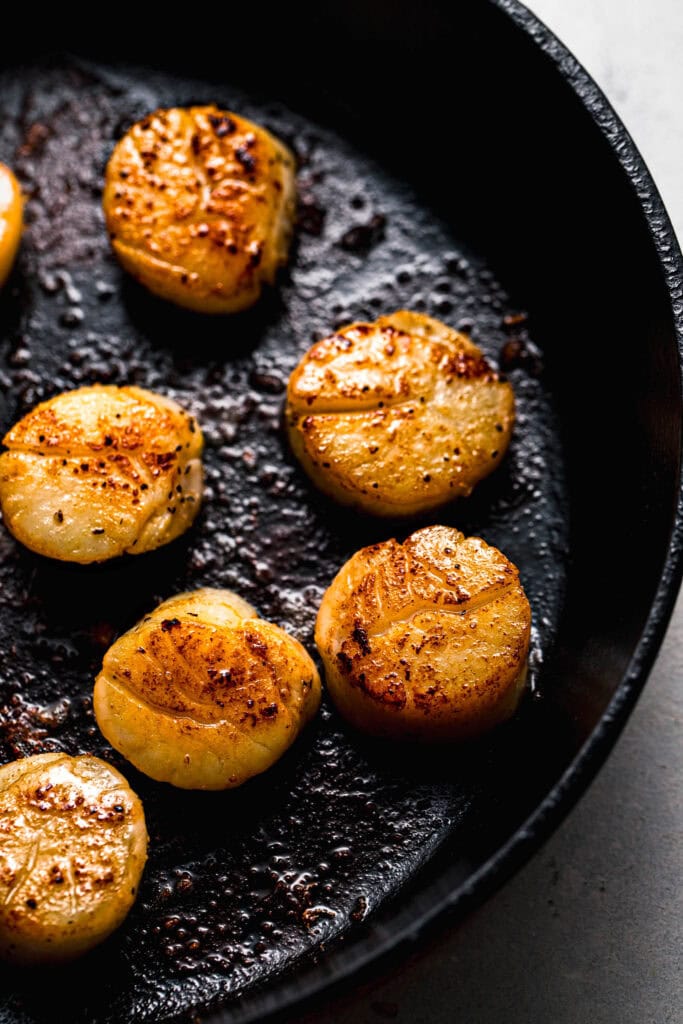 Seared scallops in cast iron skillet.