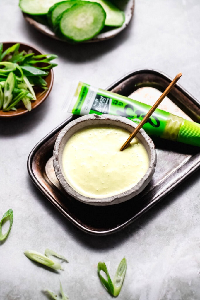 Bowl of wasabi mayo with small serving spoon.