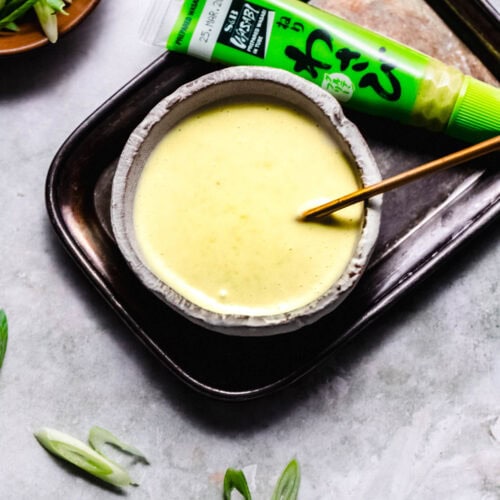 Bowl of wasabi mayo next to small tube of wasabi sauce.