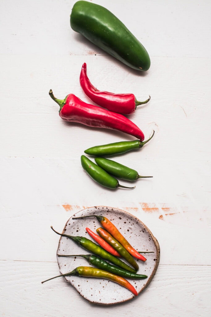 Different types of hot peppers on counter.