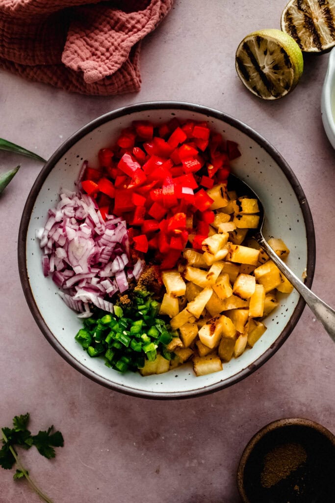 Ingredients for grilled pineapple salsa in bowl before mixing.