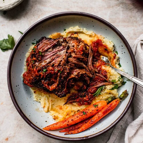 Tender short ribs in bowl with mashed potatoes.