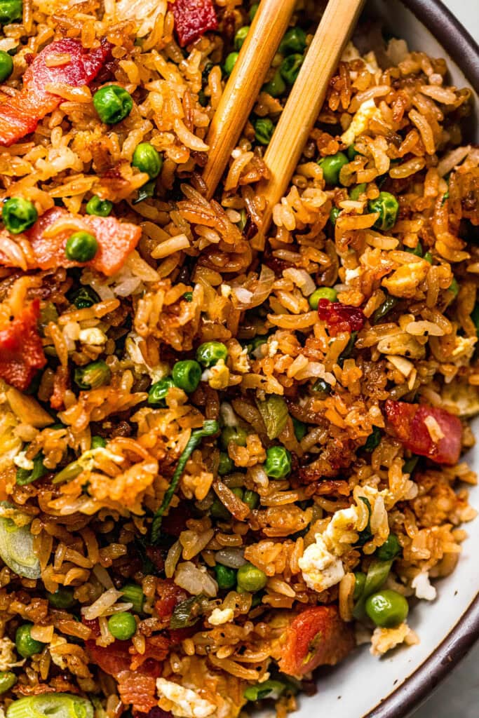 Overhead close up of fried rice in serving bowl with chopsticks.