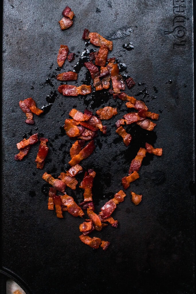Bacon cooking on flat top grill.