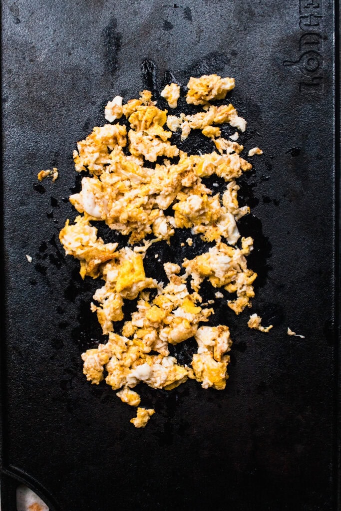 Scrambled eggs on flat top grill.