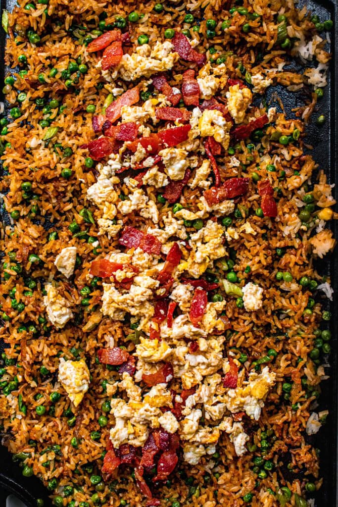 Hibachi fried rice on flat top grill topped with scrambled eggs.