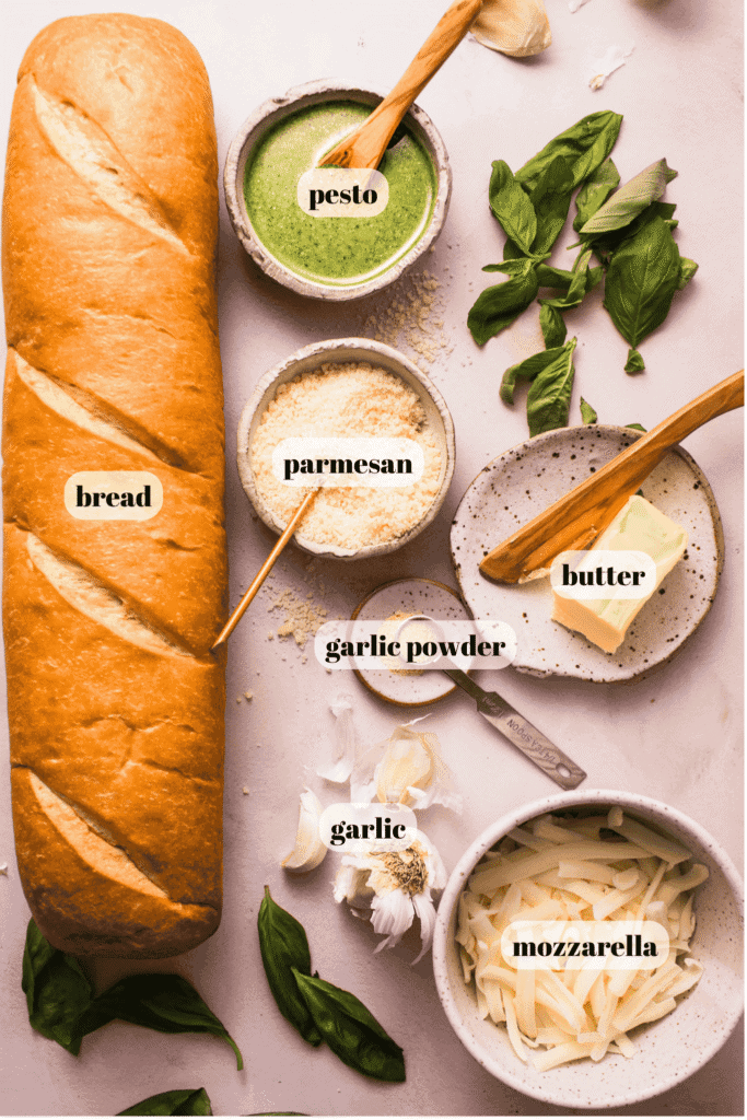 Ingredients for pesto garlic bread labeled on counter.