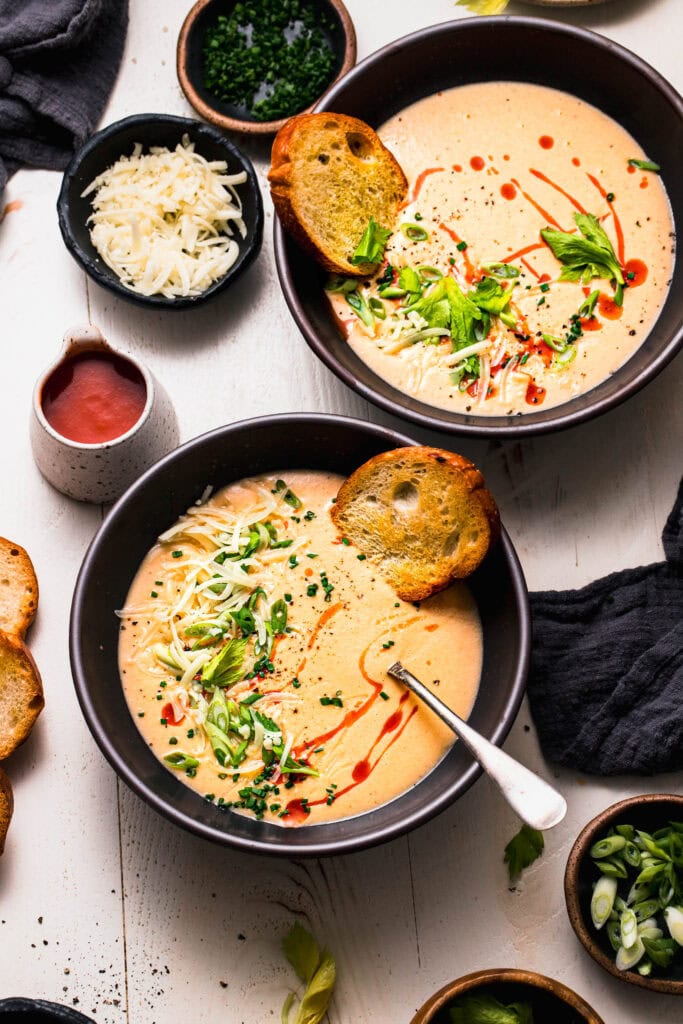 Two bowls of buffalo cauliflower soup on counter shot from overhead.