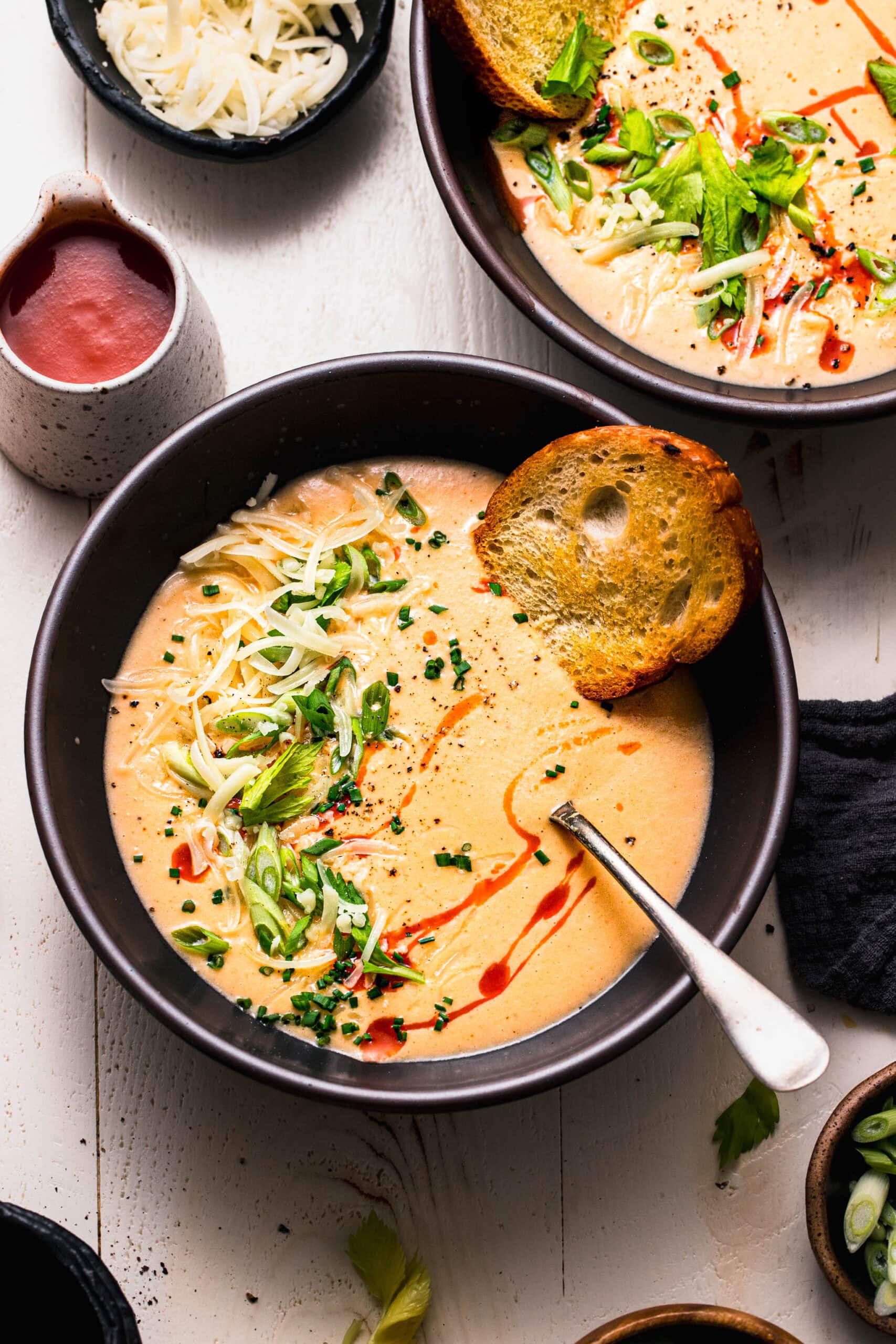 Buffalo cauliflower soup served in black soup bowl.