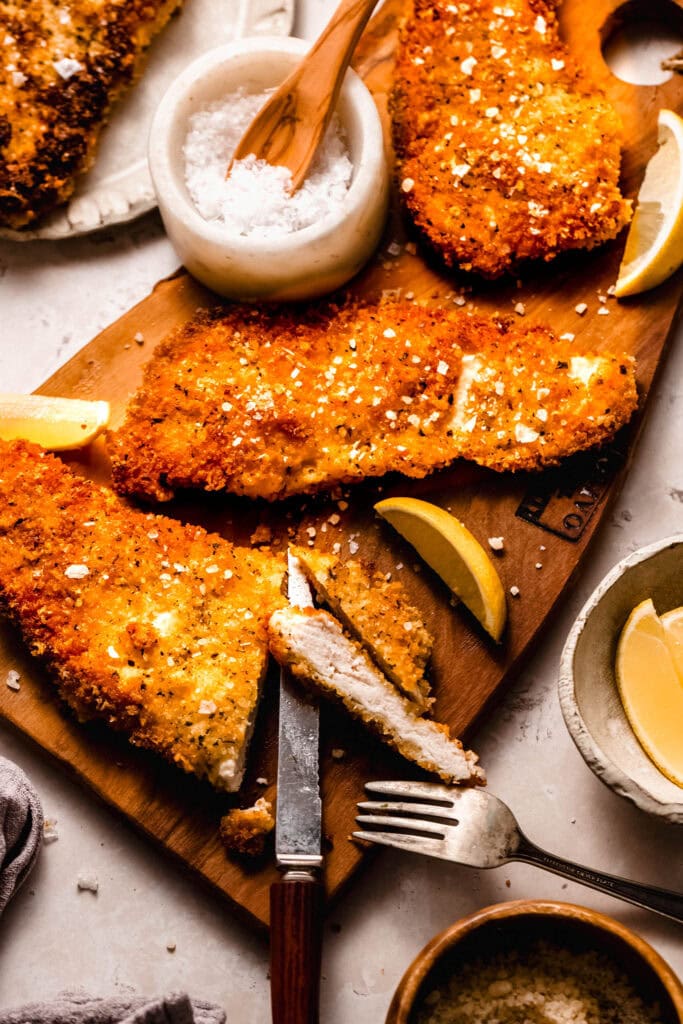 Crispy parmesan panko chicken breast being sliced into.