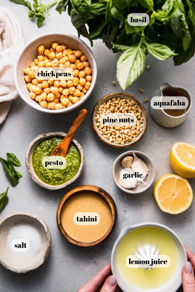 Ingredients for pesto hummus labeled on counter.