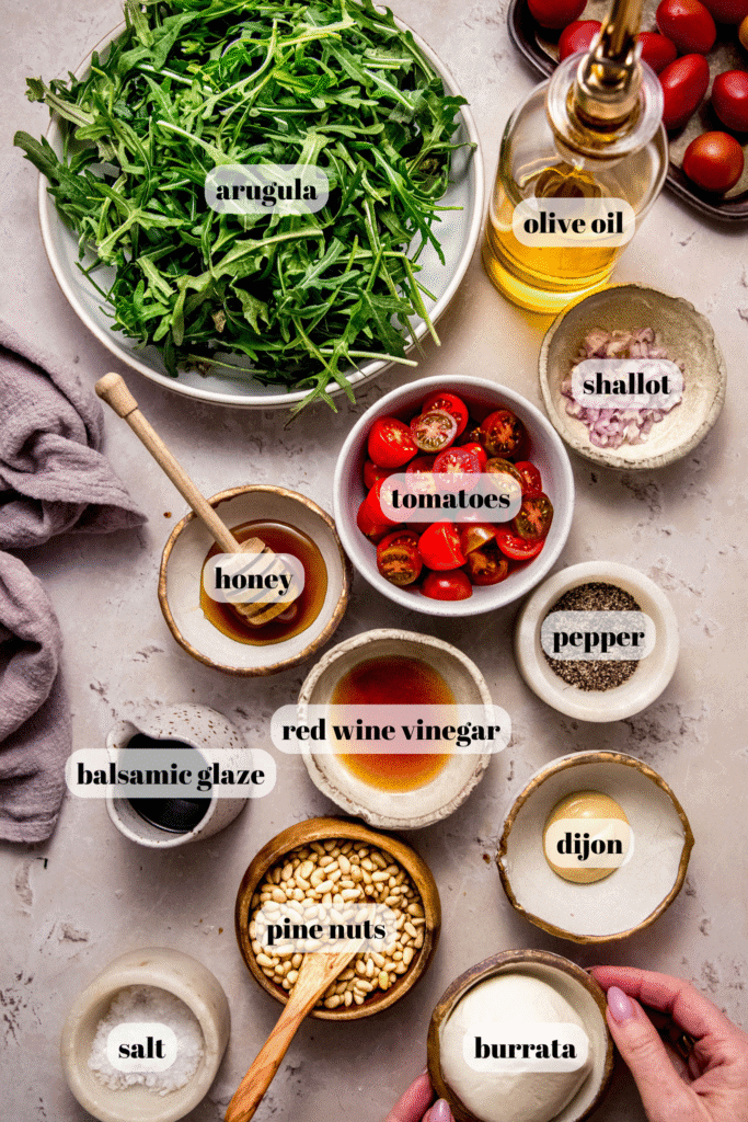 Ingredients for arugula burrata salad labeled on counter.