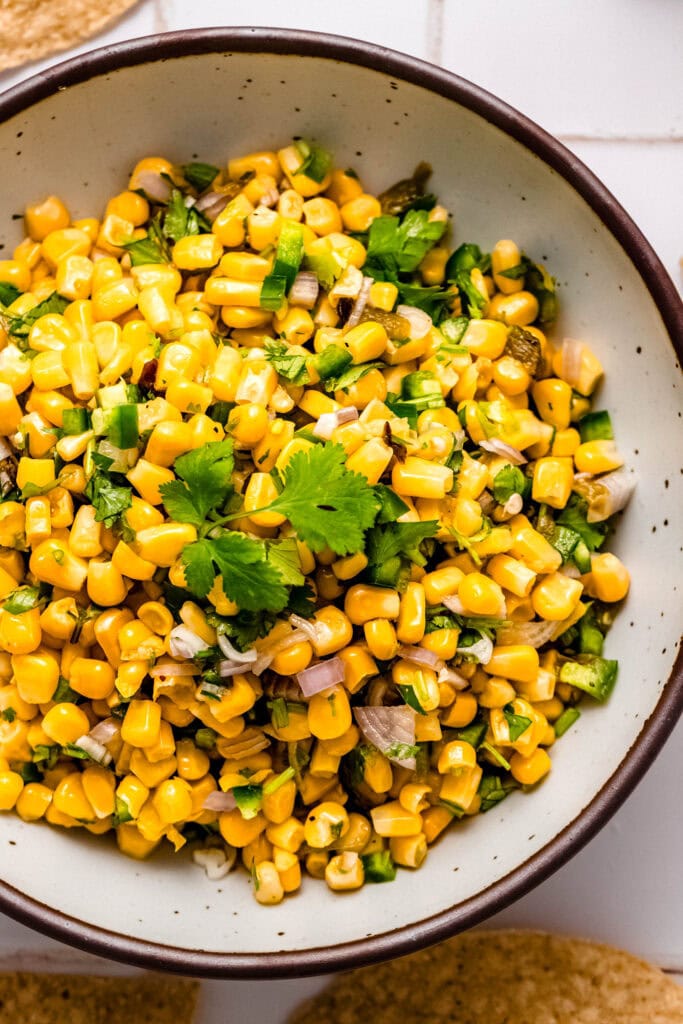 Overhead close up of copycat chipotle corn salsa in bowl topped with cilantro.