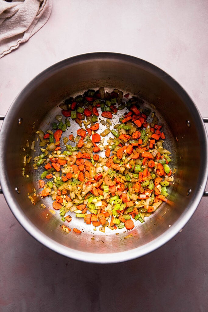 Carrots and celery sauteeing in pot.