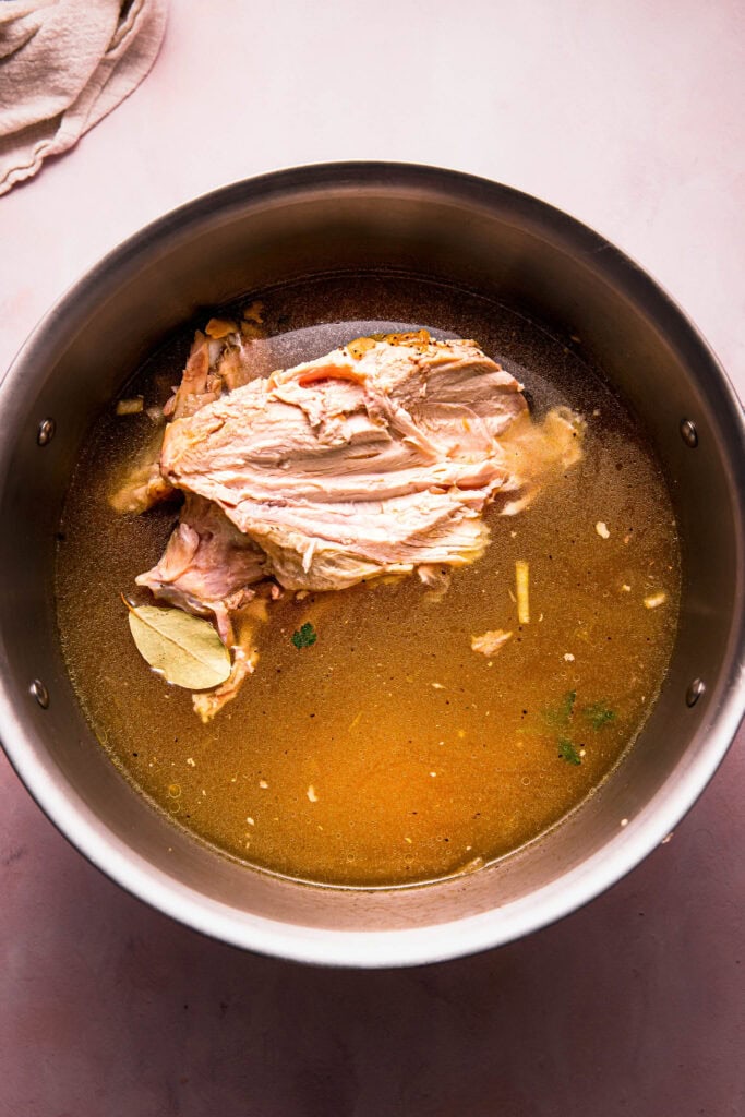 Chicken carcass added to pot.