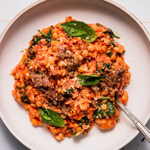 Pastina alla vodka served in white bowl with fork.
