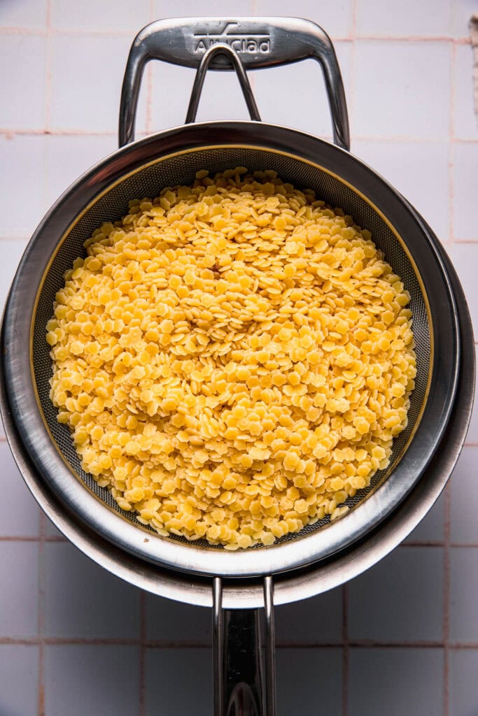 Cooked pastina in strainer.
