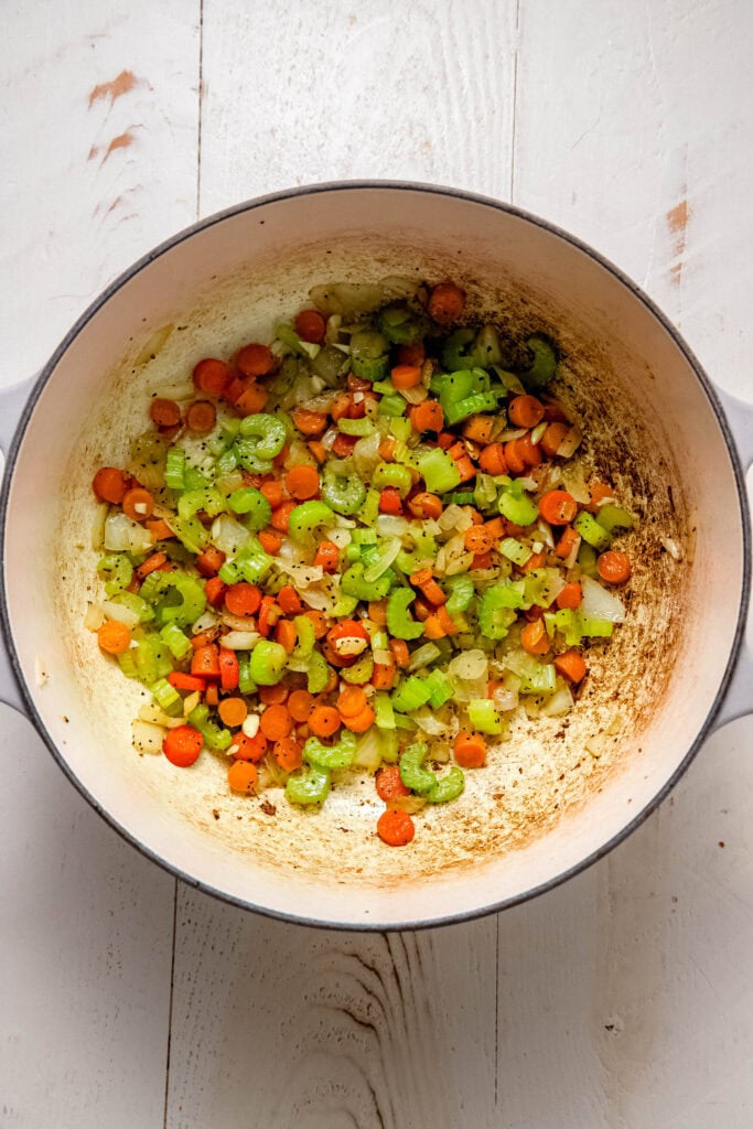 Carrots and celery cooking in pot.