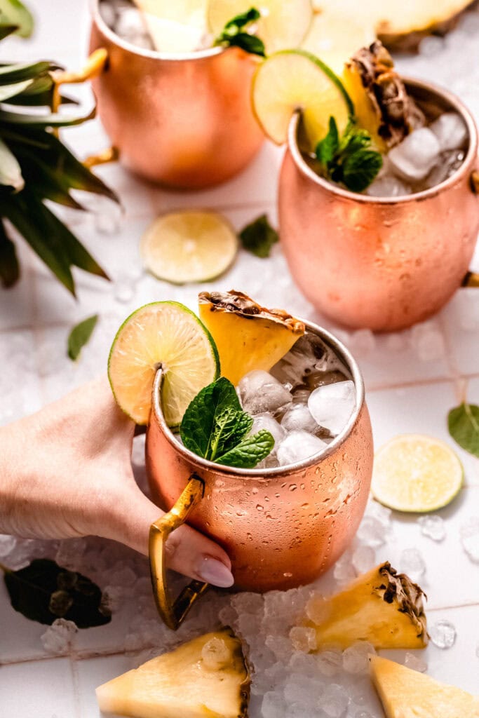 Hand holding pineapple moscow mule.
