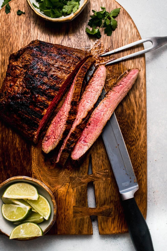 Sliced steak on cutting board.