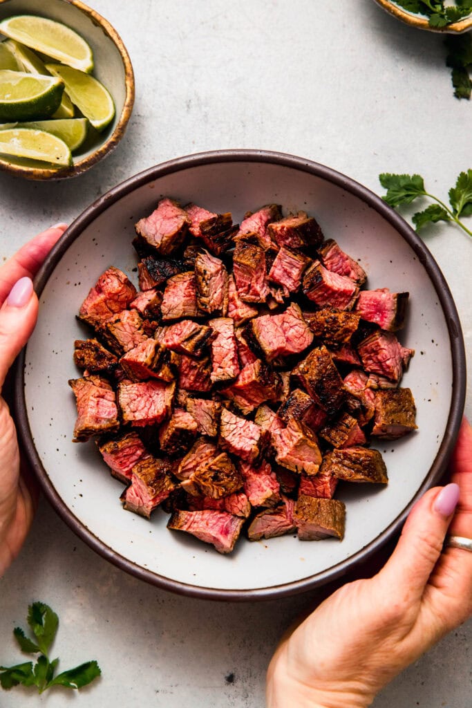 Chipotle steak cut into pieces in serving bowl.