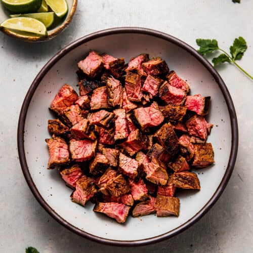 Chipotle steak cut into pieces in serving bowl.
