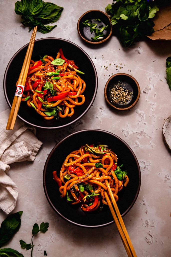 Two bowls of spicy gochujang paste noodles on counter.