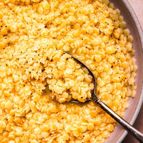 Overhead close up of spoon dipping into bowl of pastina.