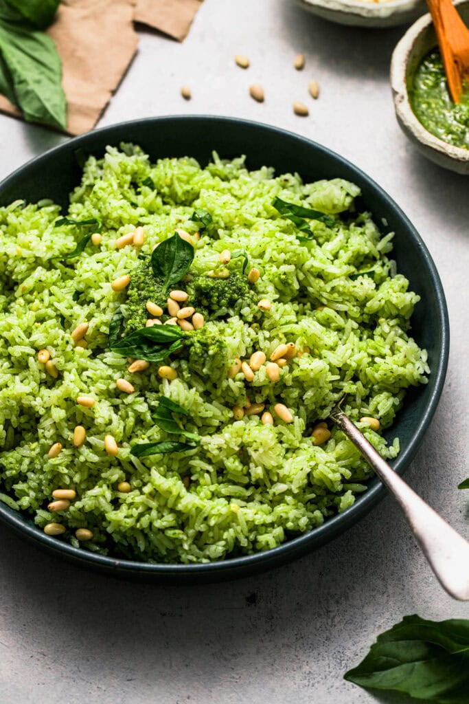 Side view of pesto rice in green serving bowl.