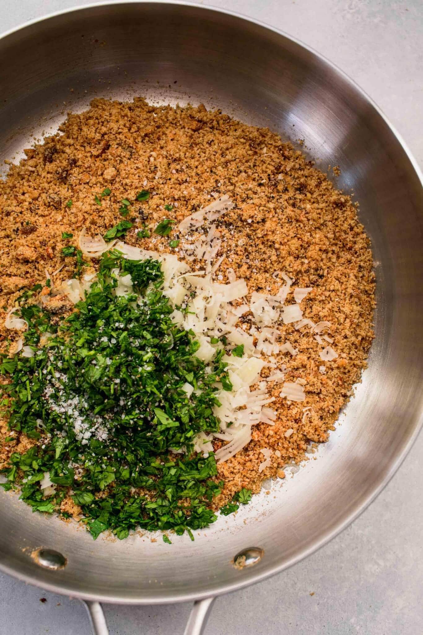 Toasted breadcrumbs in skillet with parsley and parmesan.