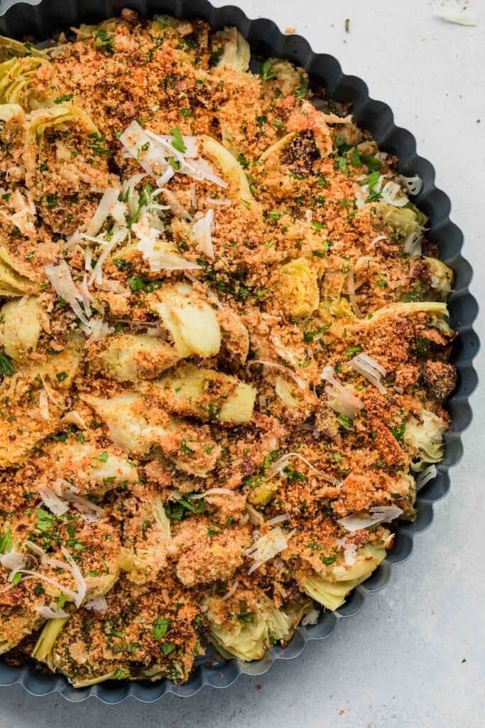 Baked artichoke hearts in baking dish after cooking.