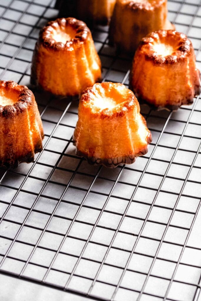 Side view of caneles on cooling rack.